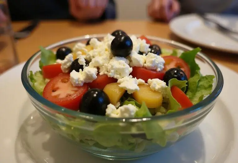 Fertiger Gyros-Schichtsalat mit Feta und Oliven, servierfertig auf dem Tisch.