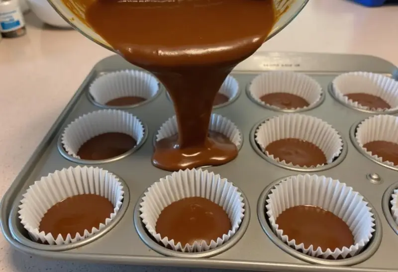 Banane Schoko Kuchen Teig wird zum Backen in Muffinförmchen gegossen.