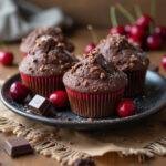 Fertige Schoko Kirsch Muffins auf einem Teller serviert, ideal für eine köstliche Leckerei.