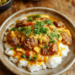 Bunter Curryreis mit saftigem Hackfleisch, verziert mit frischen Kräutern auf einem schönen Teller, die goldene Currysoße scheint cremig und aromatisch, umgeben von buntem Gemüse und Reis, die Textur des Hackfleisches ist zart, während die Gewürze den Teller lebendig machen, alles wirkt einladend und appetitlich