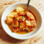 Bunte Zimtsterne auf einem weißen Teller, zart und weich mit glatter Zimtglasur, liebevoll angerichtet auf hellen Holzuntergrund, warme Farbtöne