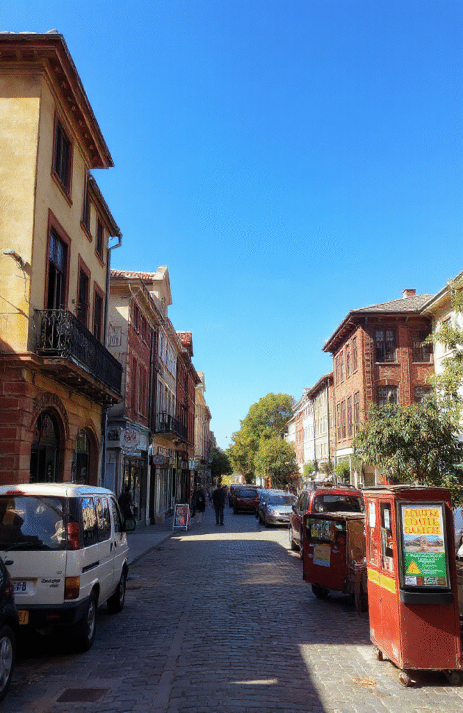 Bunter Cheeseburger-Auflauf auf einem bunten Teller, geschmolzener Käse, saftiges Hackfleisch, frische Tomaten und knackige Gurken, alles schön geschichtet und goldbraun überbacken, appetitlich angerichtet, im natürlichen Licht fotografiert.