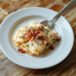 Bunte, belegte Frühstücksbrötchen auf einem Holztisch, gefüllt mit Ei, knusprigem Bacon, Käse und frischen Kräutern, appetitlich angerichtet